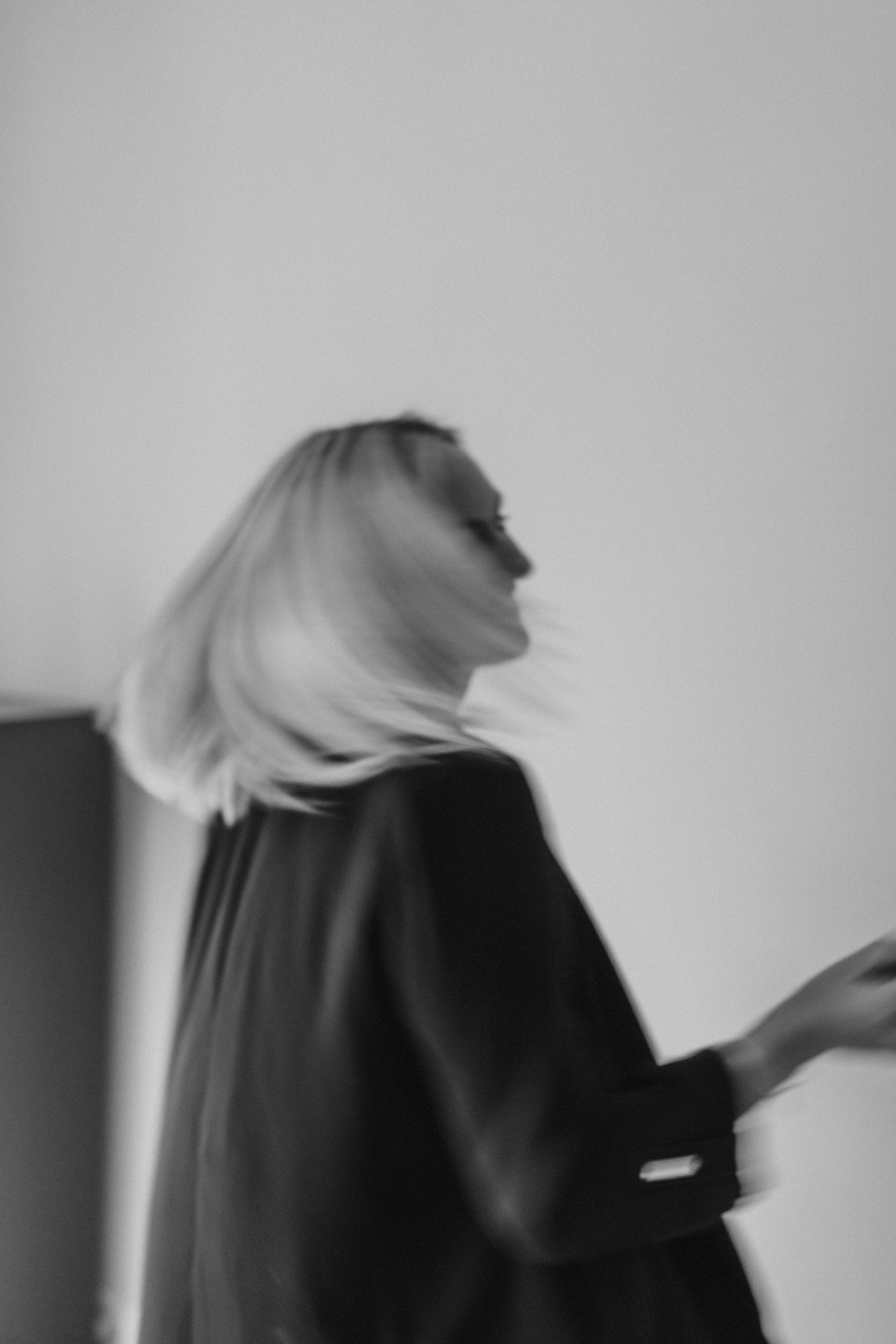 CreativebyJenn Portrait Eine lächelnde Frau dreht sich und ihre Haare schwingen dabei mit.